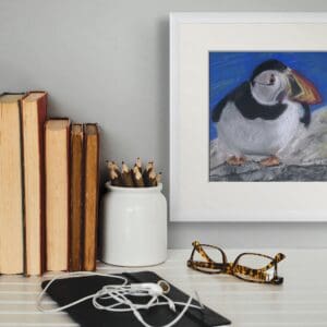 painting of a puffin hanging on a wall beside books