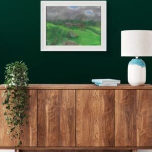 Landscape painting framed hanging on a green wall over a sideboard