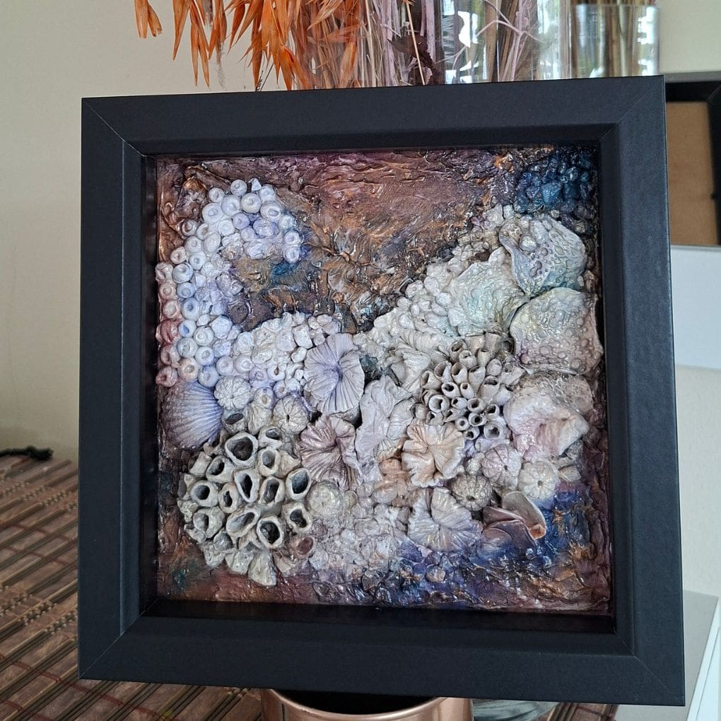 Square framed coral‑themed mixed‑media artwork with shimmering gold and purple tones.