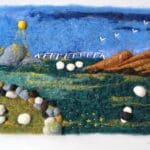 Nestled between the hills, sheep graze among fields divided by old stone walls. Needle felted using carded wool from Kerry Woollen Mills.